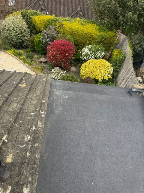 Storm Dry Roofing: neat new felt flat roof finished next to a tiled slope