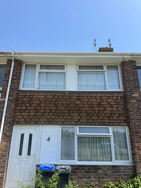 Storm Dry Roofing uPVC fascia job, after: the same house with new white uPVC fascia, soffit and guttering along the front