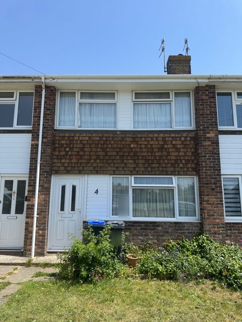 Storm Dry Roofing: new white uPVC fascia, soffit and guttering across the front of a terraced house